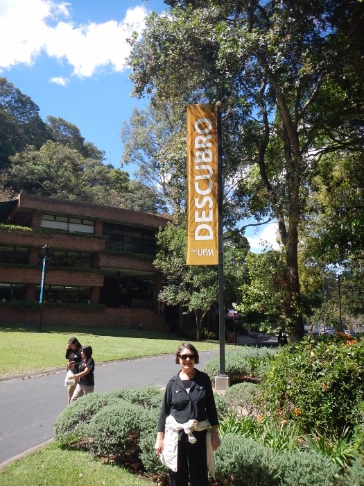 2017 Guat City kathy poses withn the University Campus in the
      background