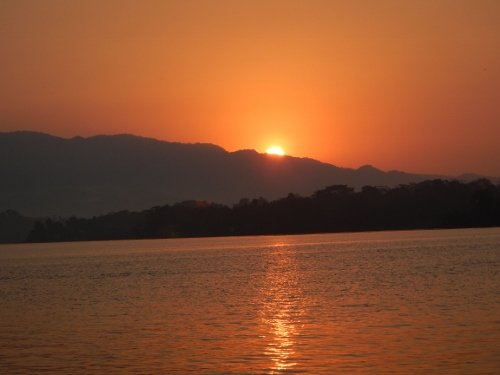 The sun peeks over Monkey Mountain as the day
          begins in the Rio