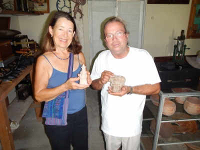 The museum owner Luis and Kathy hold whistle
          artifacts used by the Mayan Culture